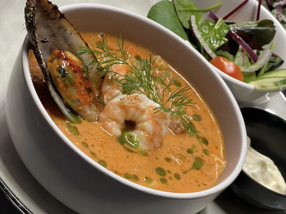 Krämig soppa på säsongens grönsaker serverad med hembakat bröd